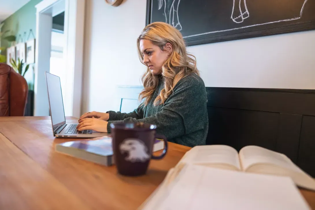 Student working on a laptop while sitting in a coffee shop